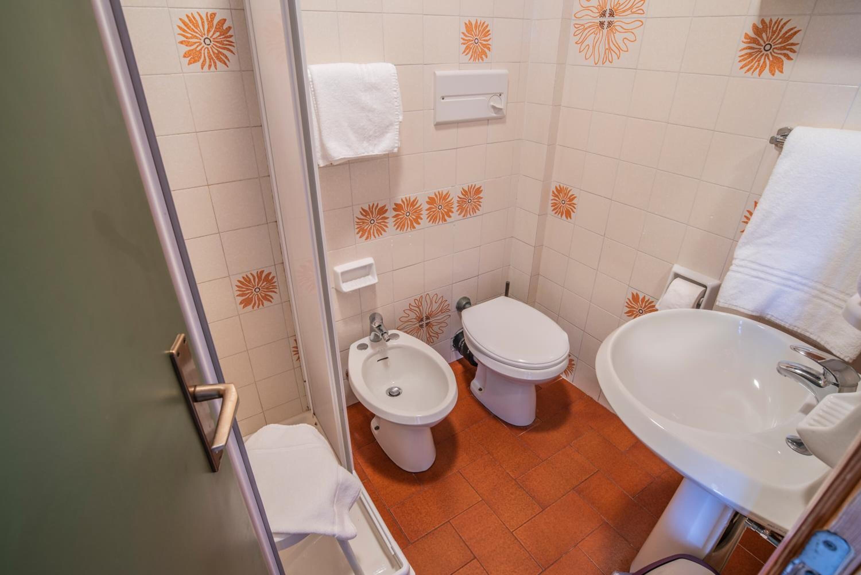 Un baño con bidé, inodoro y lavabo.
