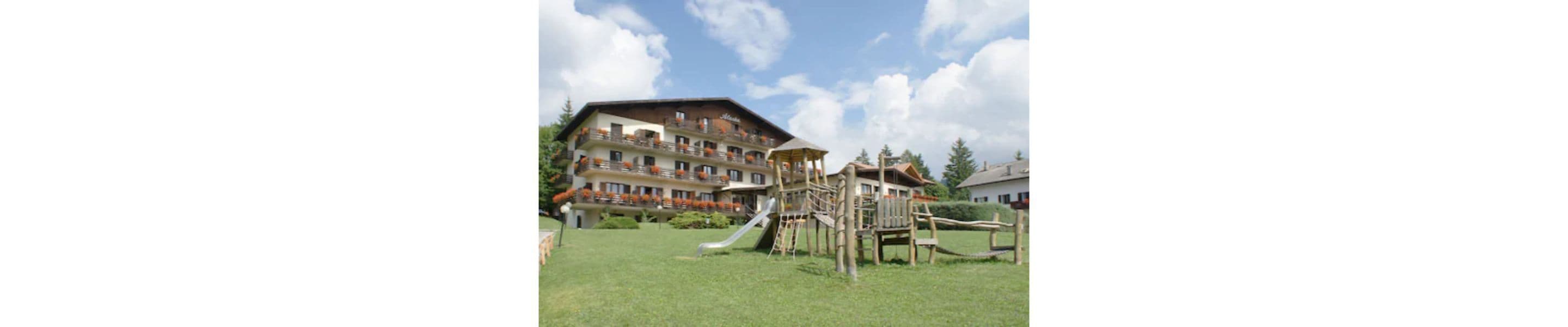 A hotel with a playground area, including a slide and climbing structures.