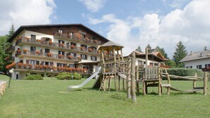 Un hotel con varios balcones, un área de juegos y un tobogán.