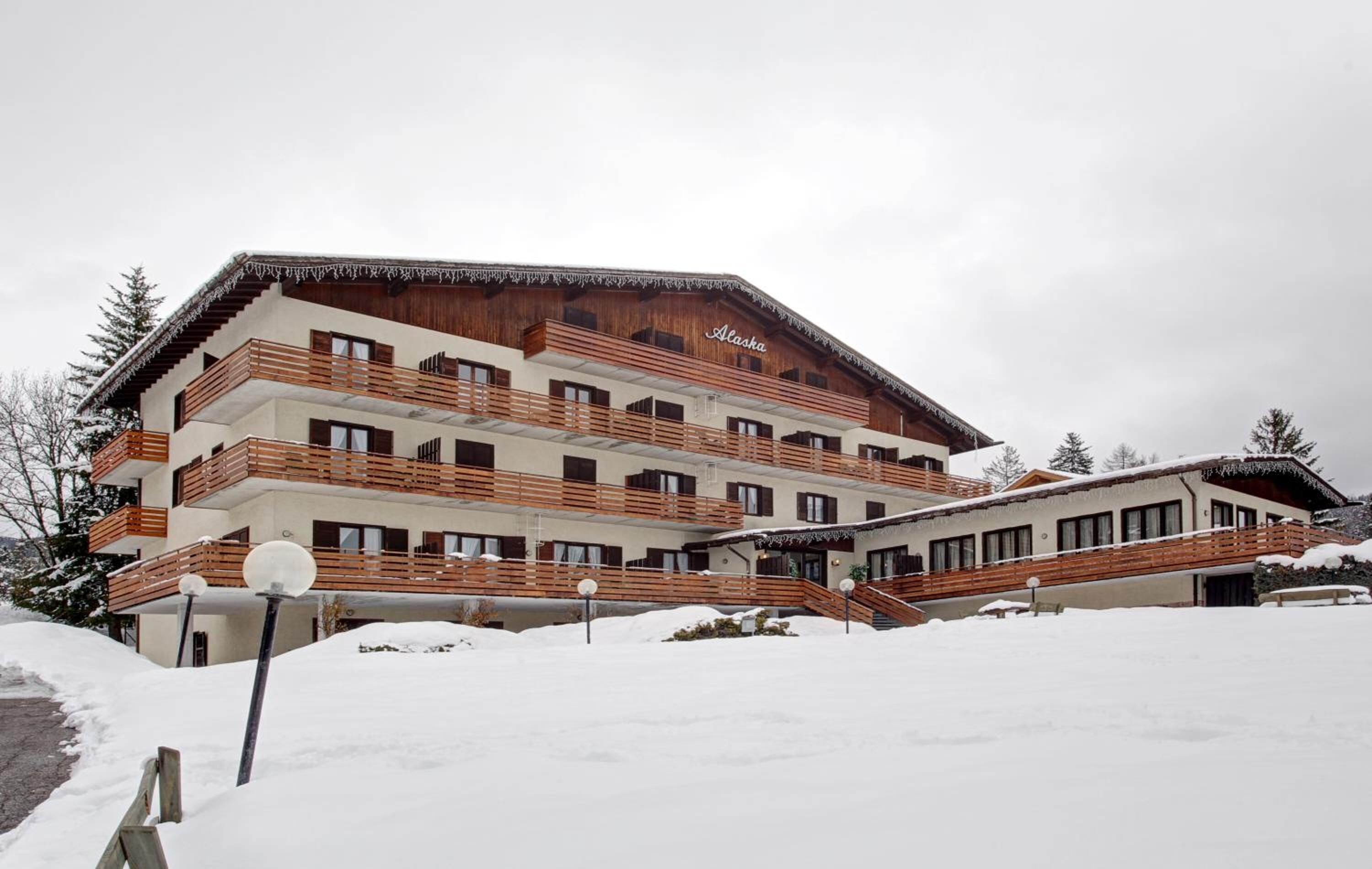 A multi-story building with wooden balconies and a sign that reads "Alaska."