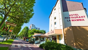 A hotel named "Hotel Restaurant La Mamma" with a modern design, a covered outdoor seating area, and a clear view of the street. - ibis Styles Annecy Le Vieux (Annecy)
