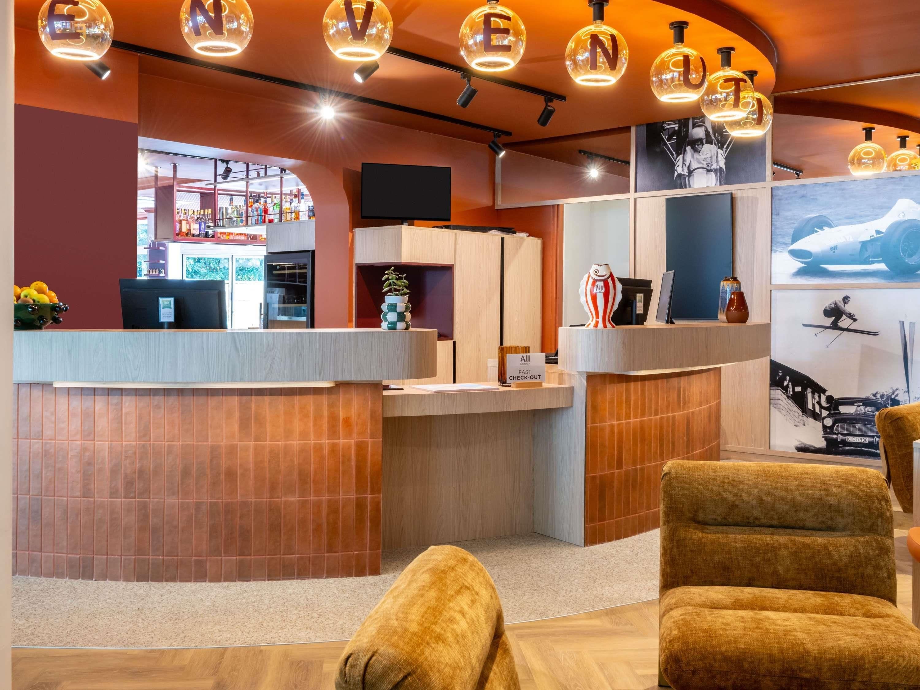 A reception area with a curved desk, a TV, and a sign indicating a fast check-out service.