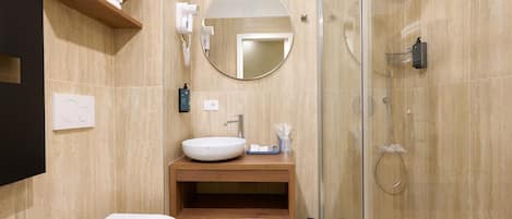 Un baño moderno con inodoro, lavamanos y ducha.