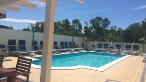 Ein Poolbereich mit Liegestühlen und einer Pergola.