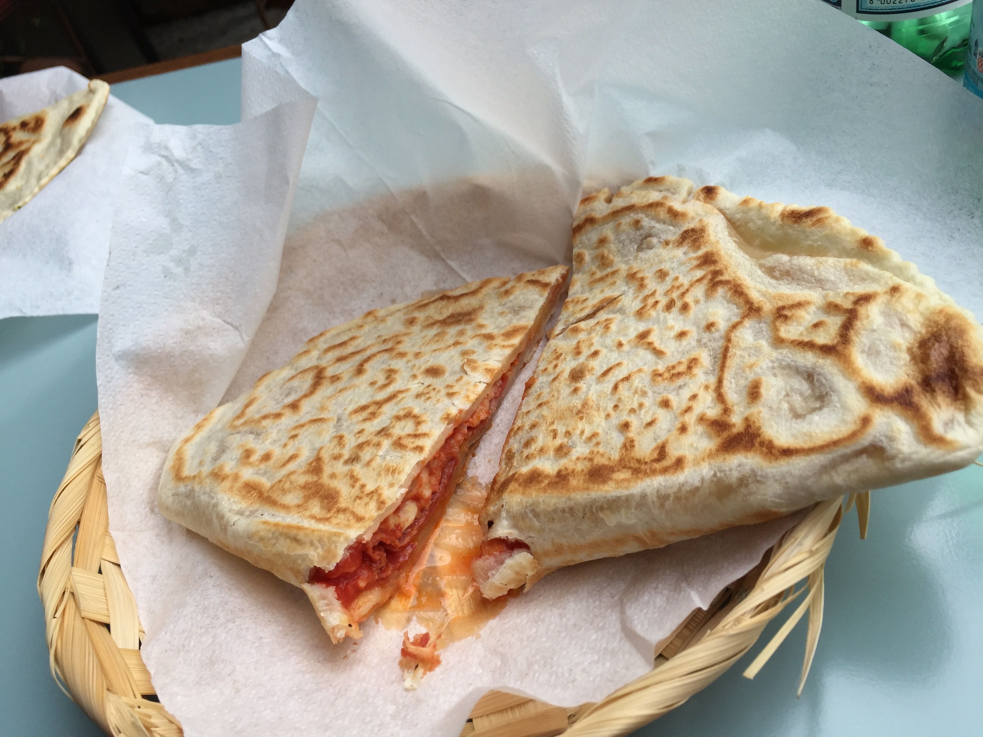 Una quesadilla a medio comer en una cesta tejida.