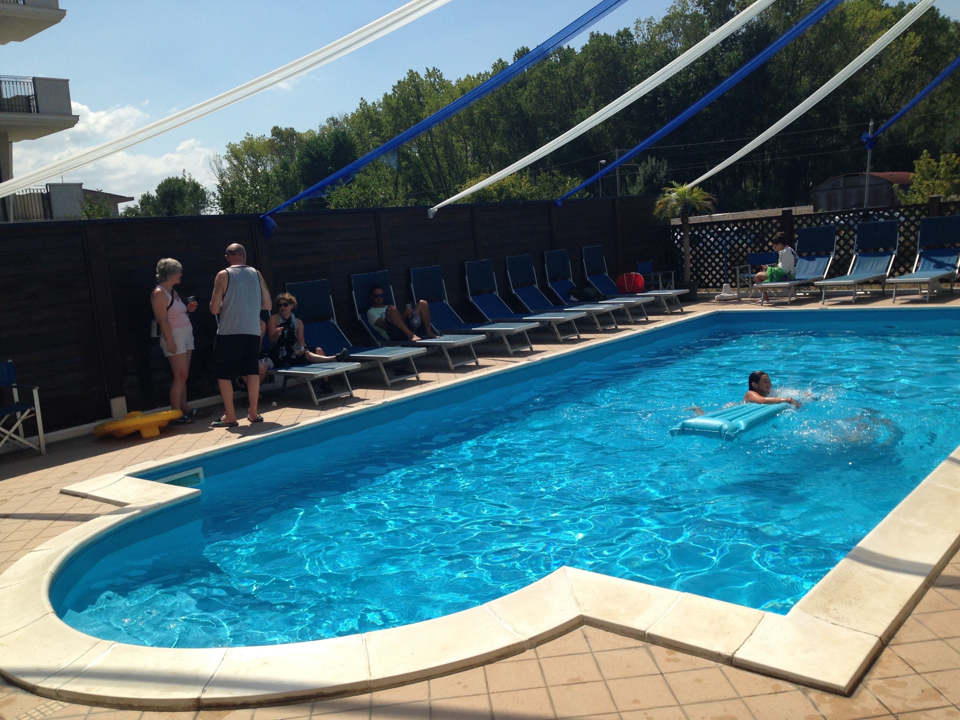 En swimmingpool med liggestole og et område med jacuzzi.