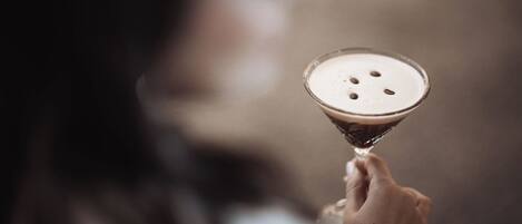 Eine Person hält ein Martini-Glas mit Schaumkrone.