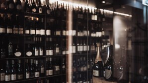 A wine rack with multiple bottles, including Krug champagne, in a dimly lit setting. - Hotel Montis - Schönblick (Brunico)