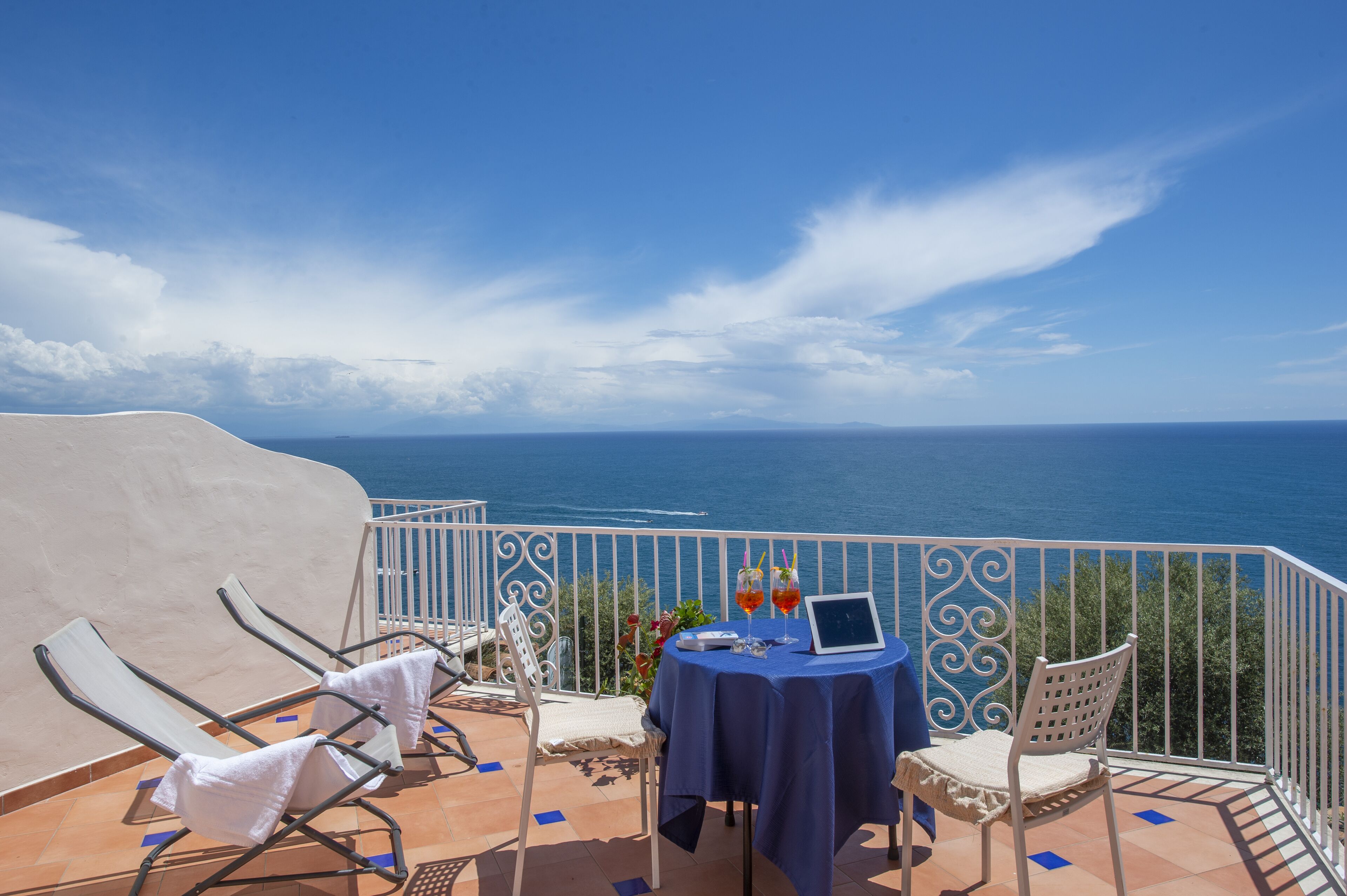 Una terraza con mesa y sillas, con vistas al mar.