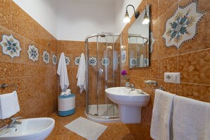 A bathroom with two sinks, a glass shower enclosure, and decorative tiles.
