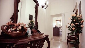 A hallway with a wooden console table, a mirror, and a potted plant. - Marta Guest House (Rome)