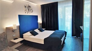 Une chambre d’hôtel avec un grand lit, une table de chevet, un bureau et une chaise.