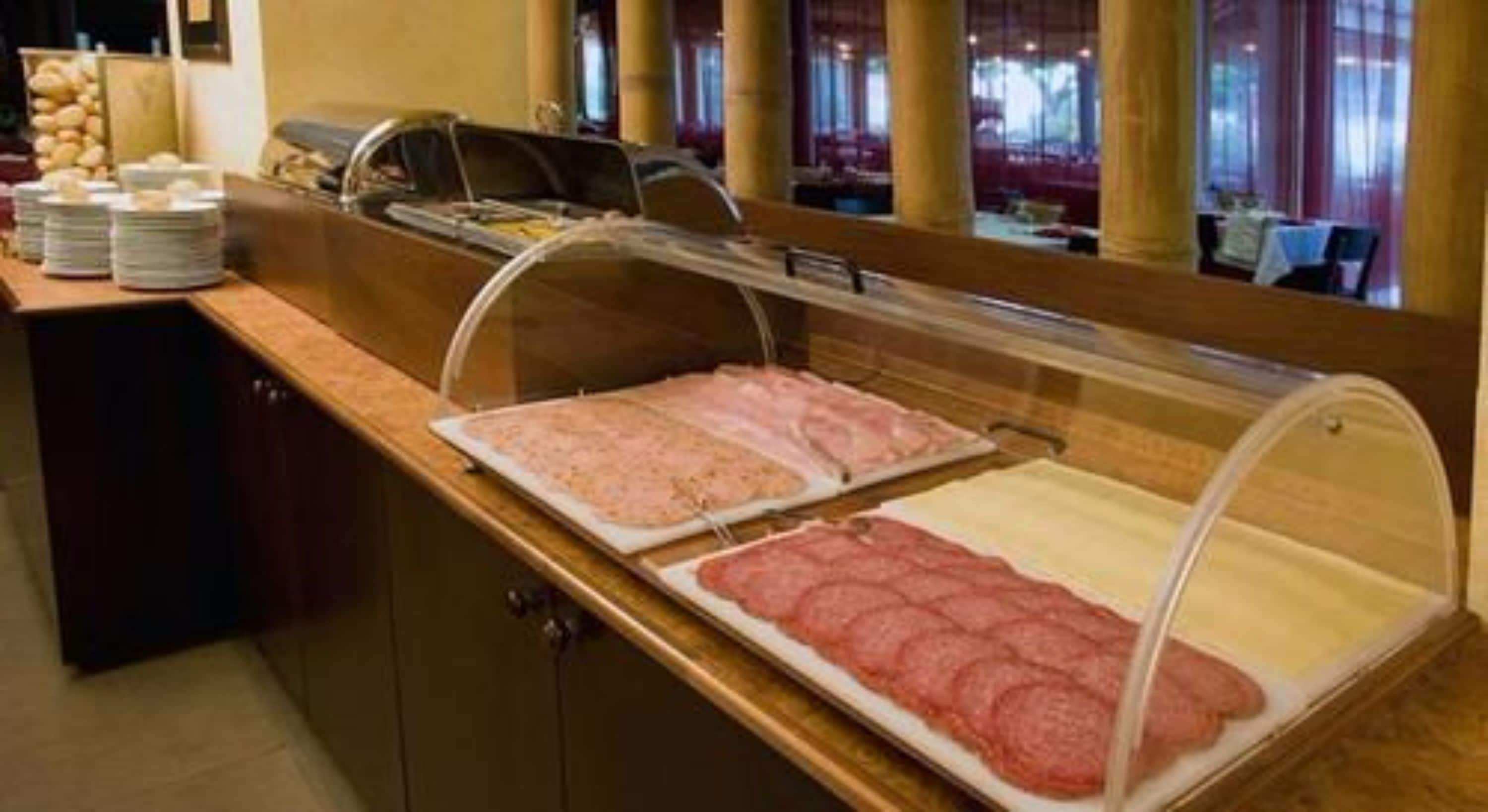 A buffet area with various food options, including sliced meats and a salad bar.