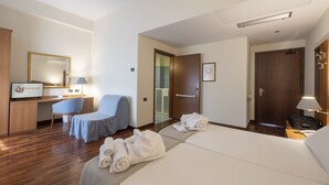 Une chambre d’hôtel comprenant un lit, un bureau, une chaise, une salle de bain et un espace douche.