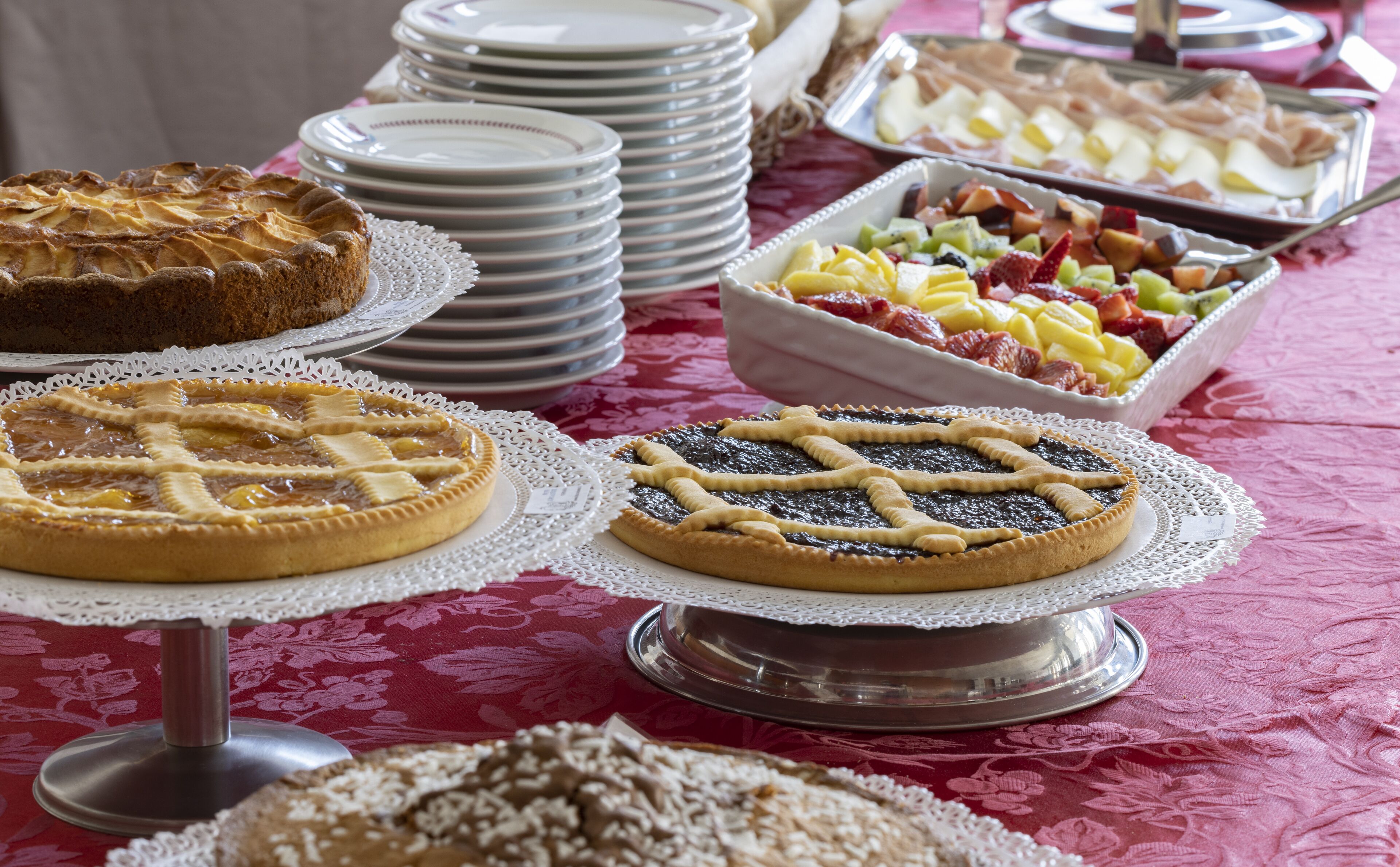 A table with various desserts, including pies and fruit.