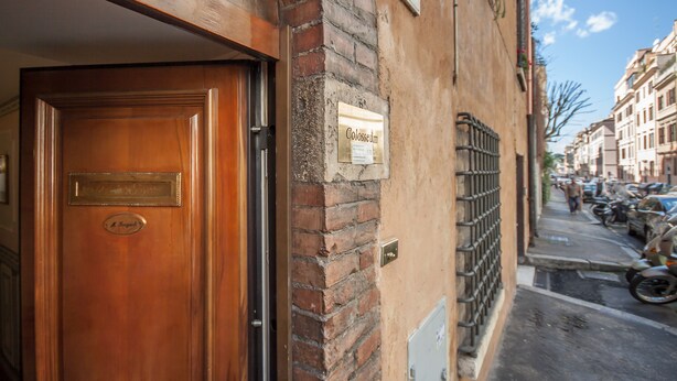 Una calle estrecha con una puerta de madera y un letrero que dice "Colosseum".