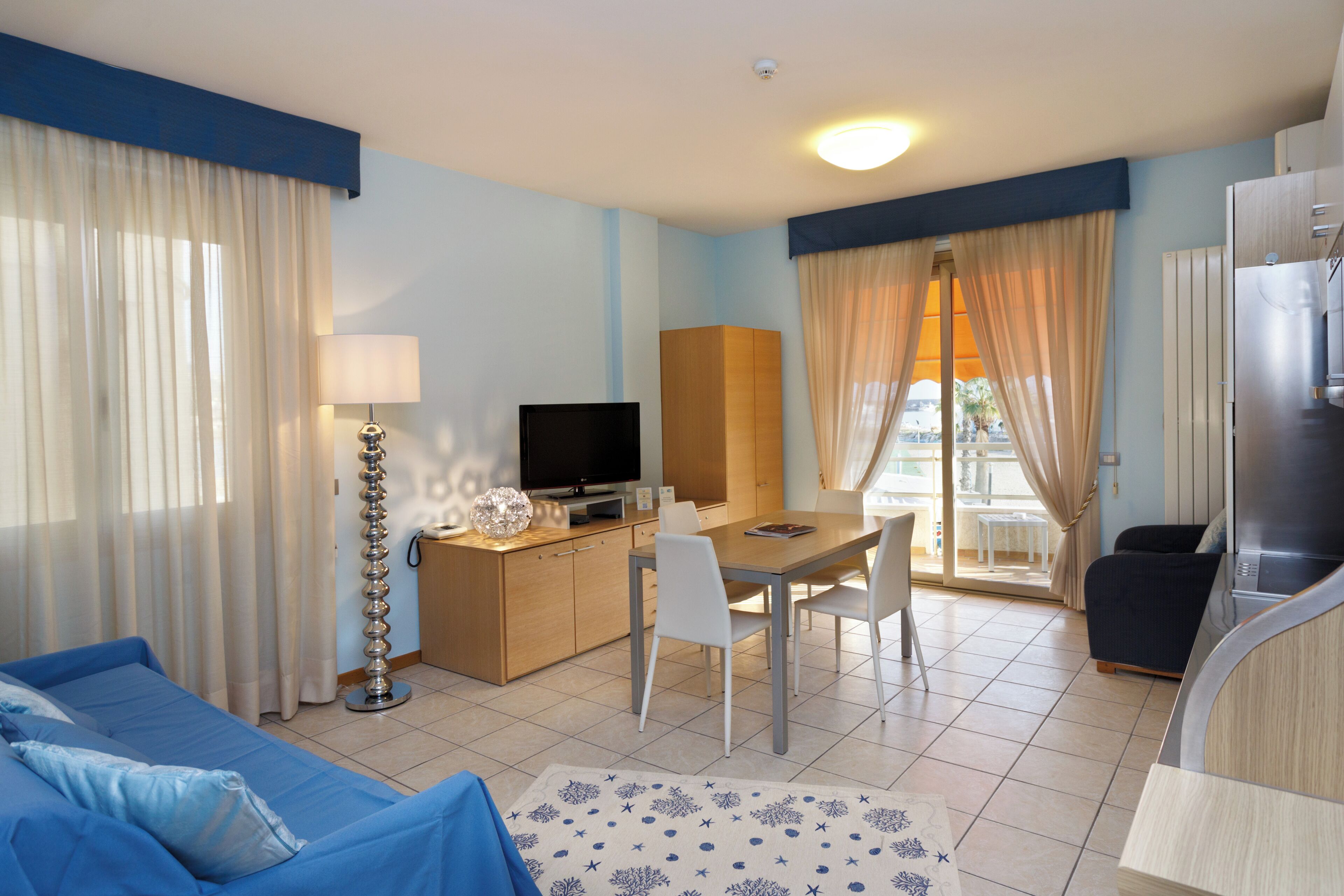 Une chambre d’hôtel comprenant un lit, une télévision, un coin repas et une kitchenette.