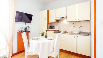 A compact kitchen with a microwave, sink, and wooden cabinets.