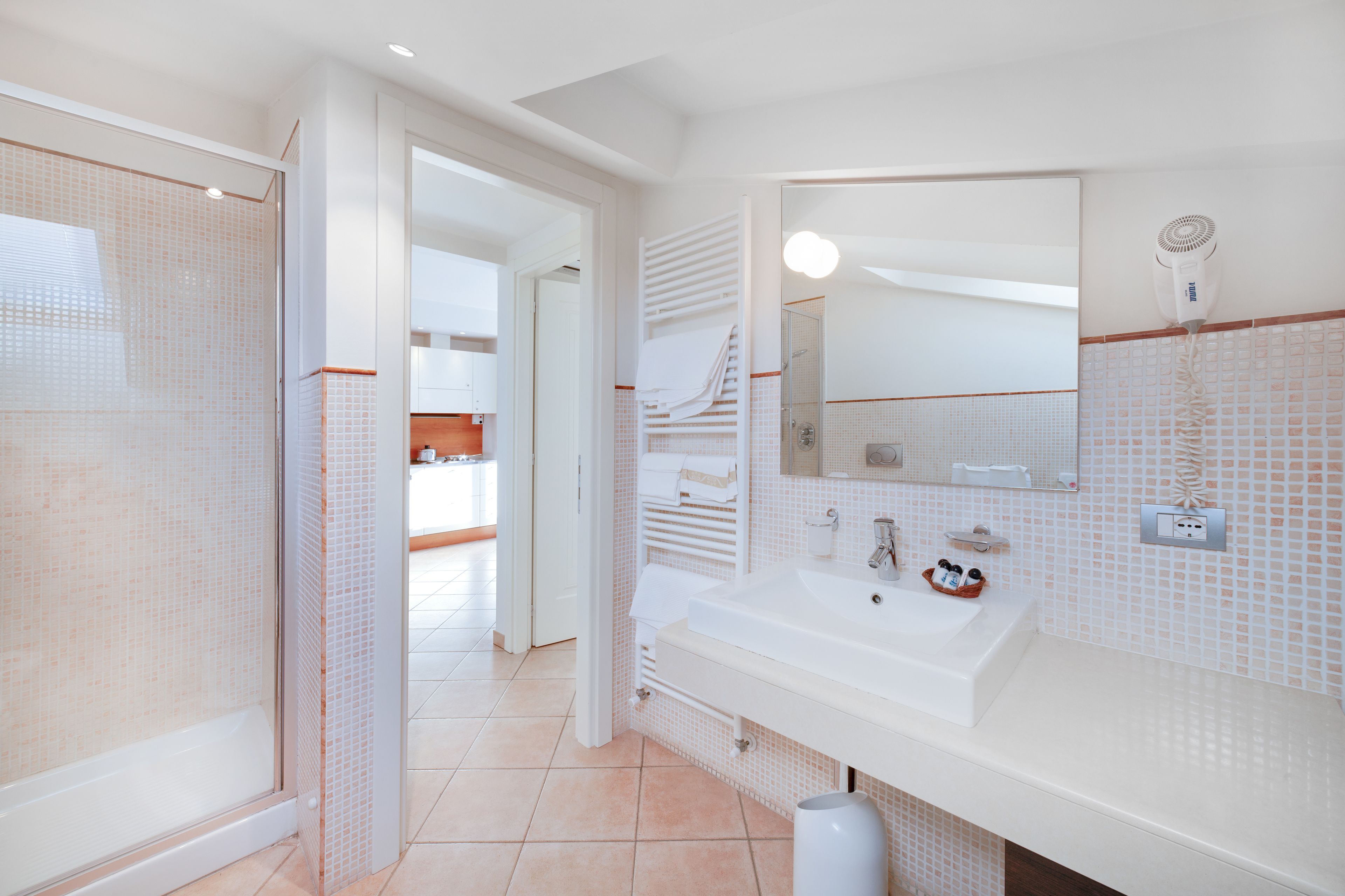Un bagno moderno con doccia, lavandino e specchio.