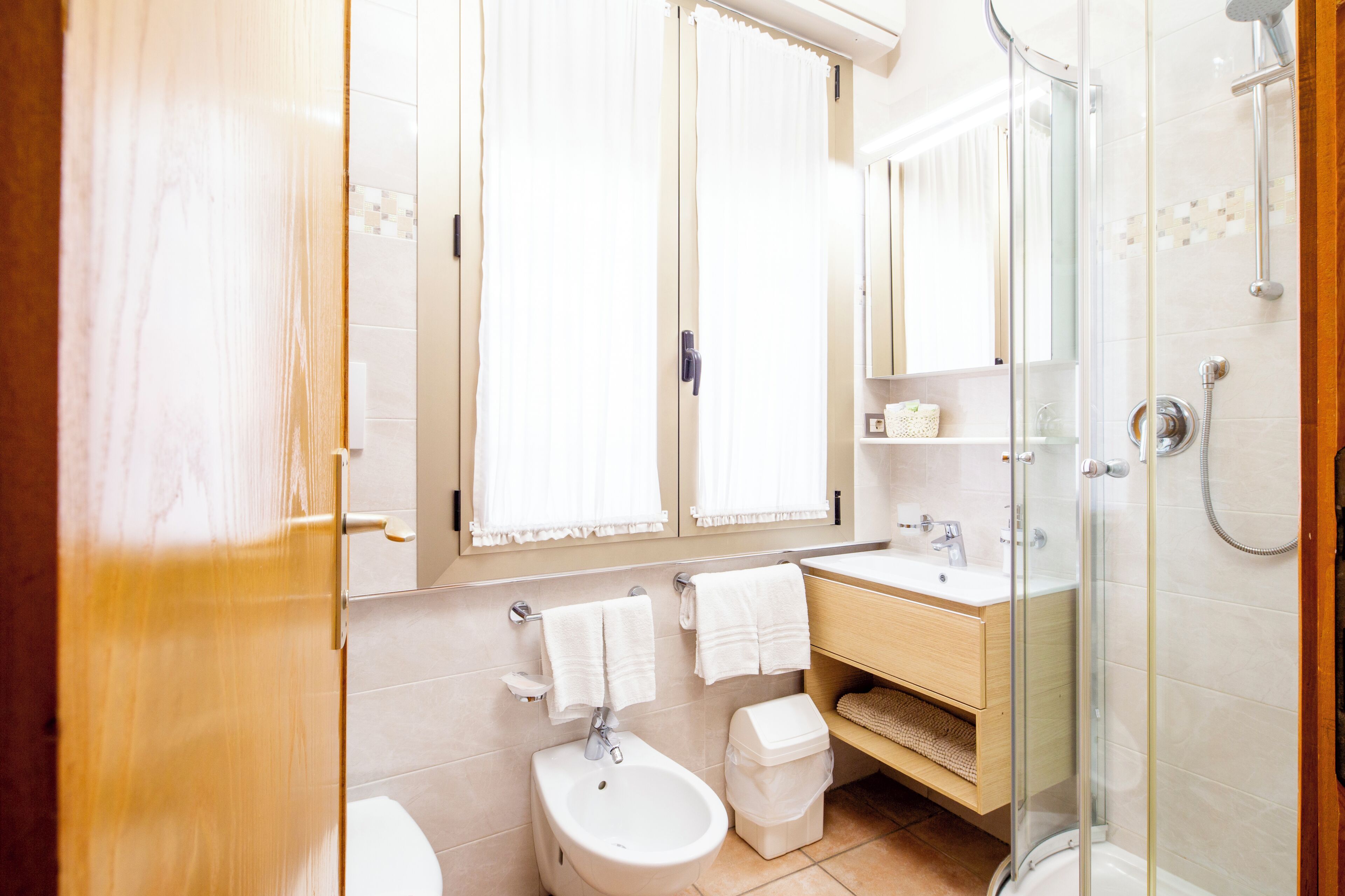 A modern bathroom with a toilet, bidet, sink, and shower.
