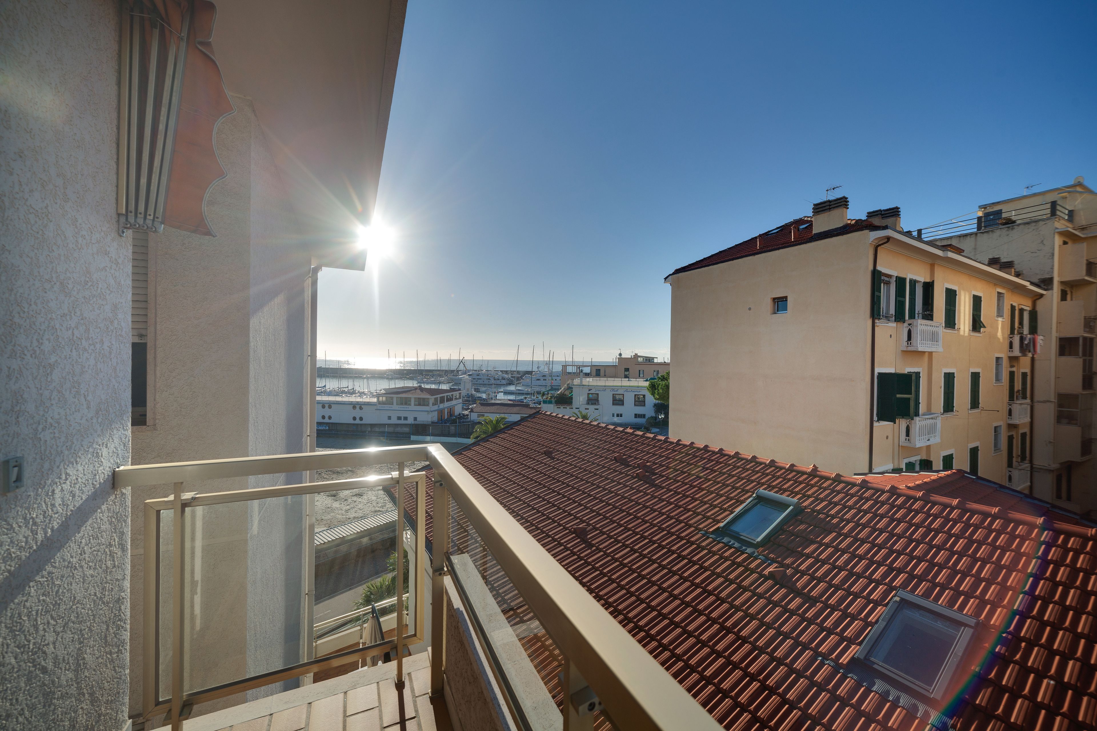 A balcony with a view of a cityscape and a clear sky.