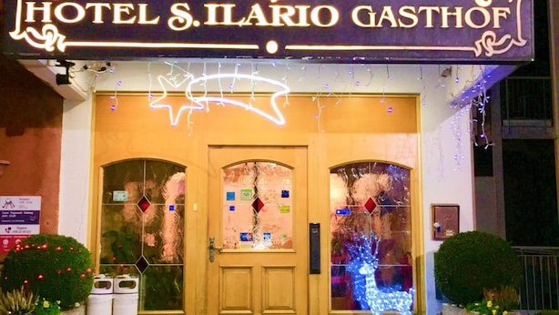 Het uiterlijk van Hotel S. Ilario Gasthof, met een opvallende ingang met een decoratieve boog en verlichte signage.