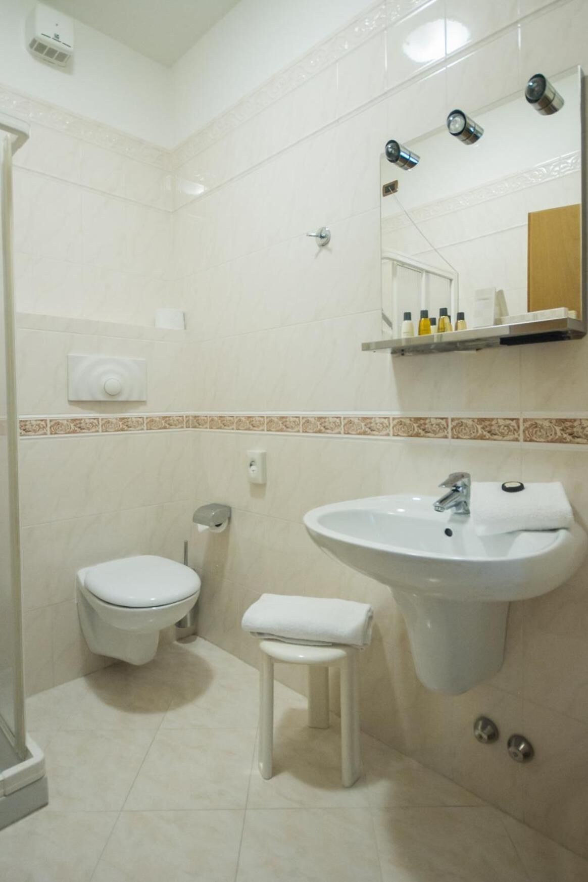 A bathroom with a toilet, sink, and shower.