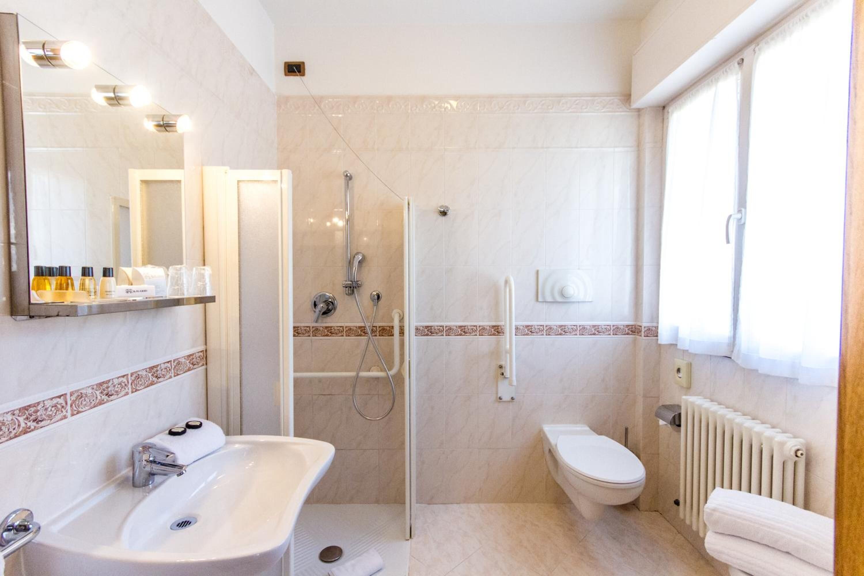 A modern bathroom with a glass-enclosed shower, a white sink, and a toilet.