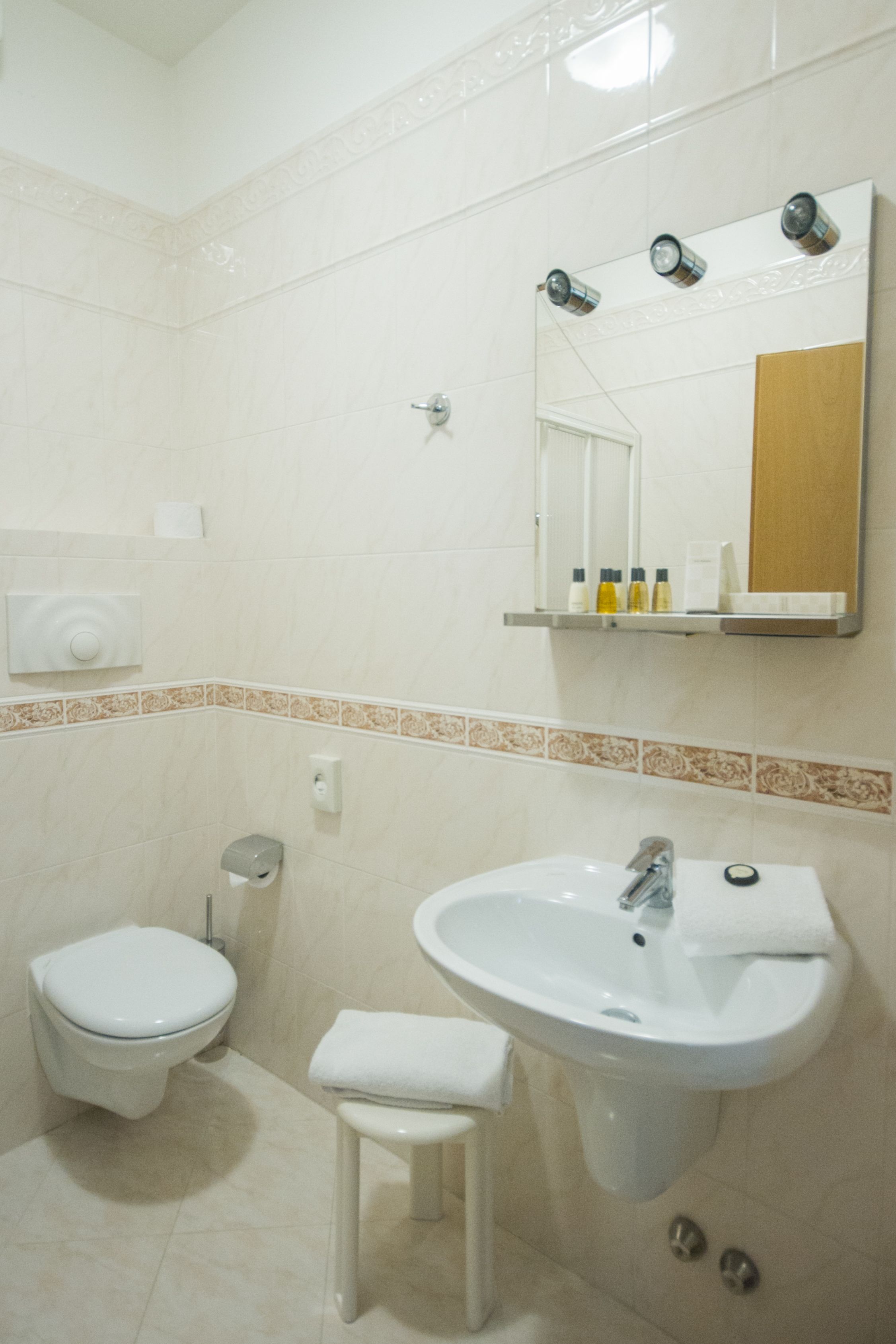 Un baño con inodoro, lavamanos y espejo.