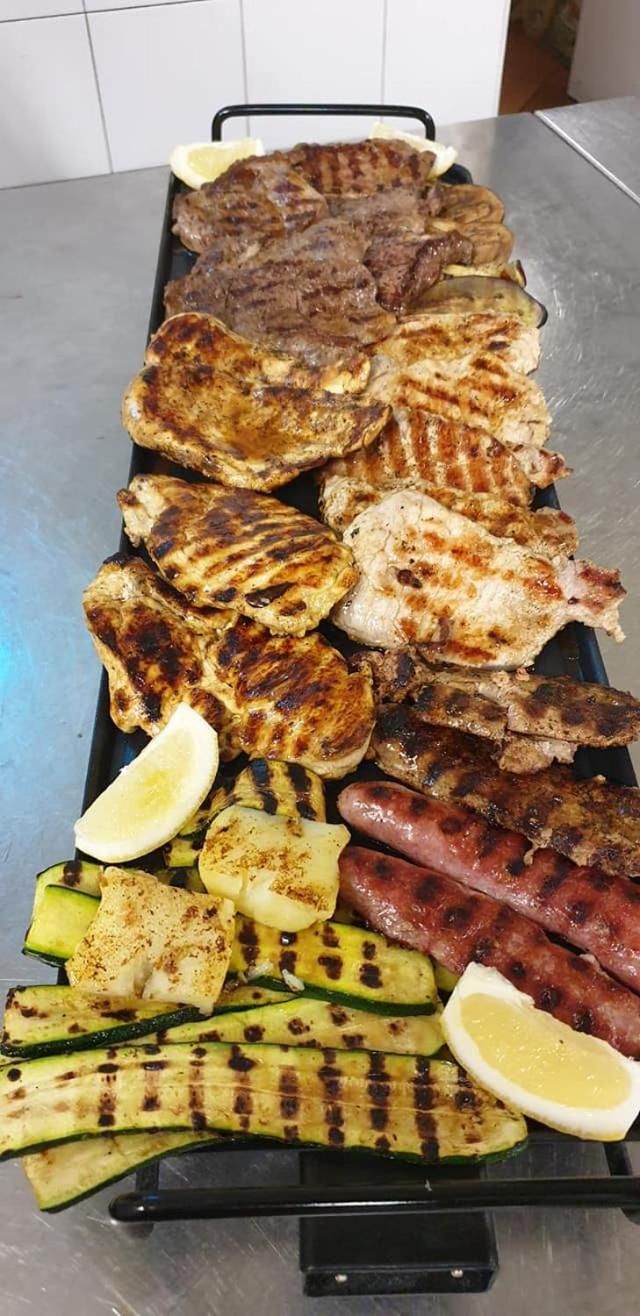 A variety of grilled meats and vegetables on a tray.