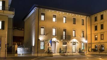 Ein Hotel mit einer klassischen Fassade, zahlreichen Fenstern und einem ehrfurchtgebietenden Eingangstor.
