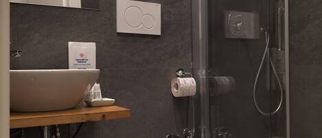 Un baño moderno con cabina de ducha de vidrio, inodoro blanco y lavabo.
