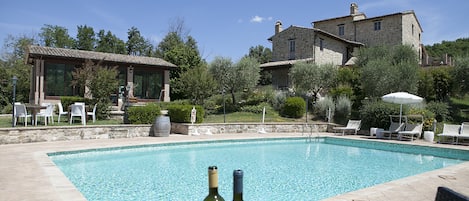 A swimming pool with lounge chairs and a table with bottles.