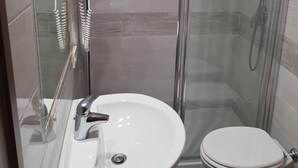 A modern bathroom with a glass-enclosed shower, a white sink, and a toilet. - Rudy B&B (Rome)