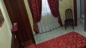 A room with a bed, a chair, a door, and curtains. - Rudy B&B (Rome)