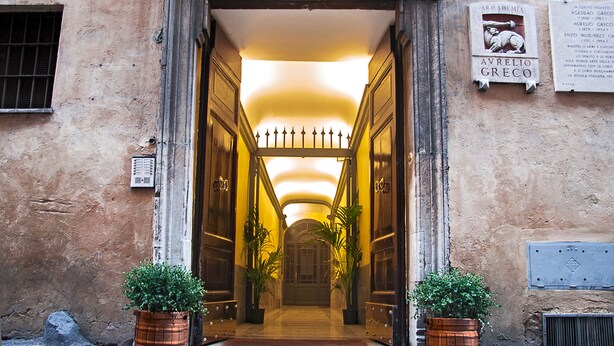 A grand entrance with a double door, a tiled floor, and potted plants at the entrance. - Pantheonview - Luxury Suites (Rome)