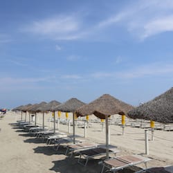 On the beach, white sand, sun-loungers, beach umbrellas