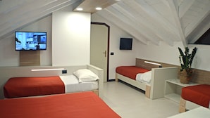 A modern hotel room with two single beds, a TV, and a potted plant.