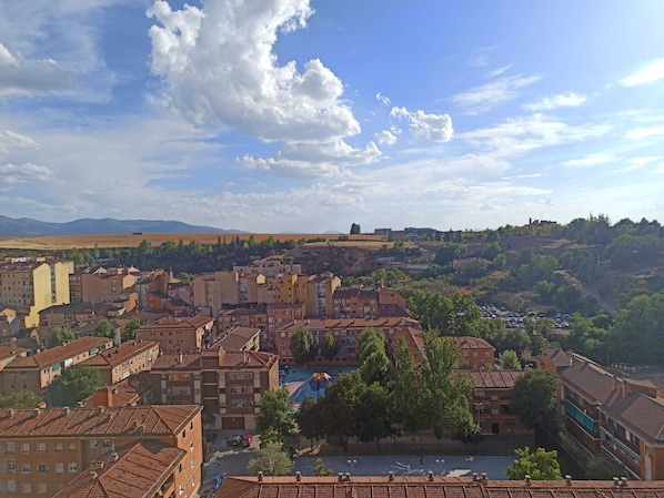A cityscape with a mix of residential and commercial buildings, a clear sky, and distant hills. - Hotel Real Segovia (Segovia)