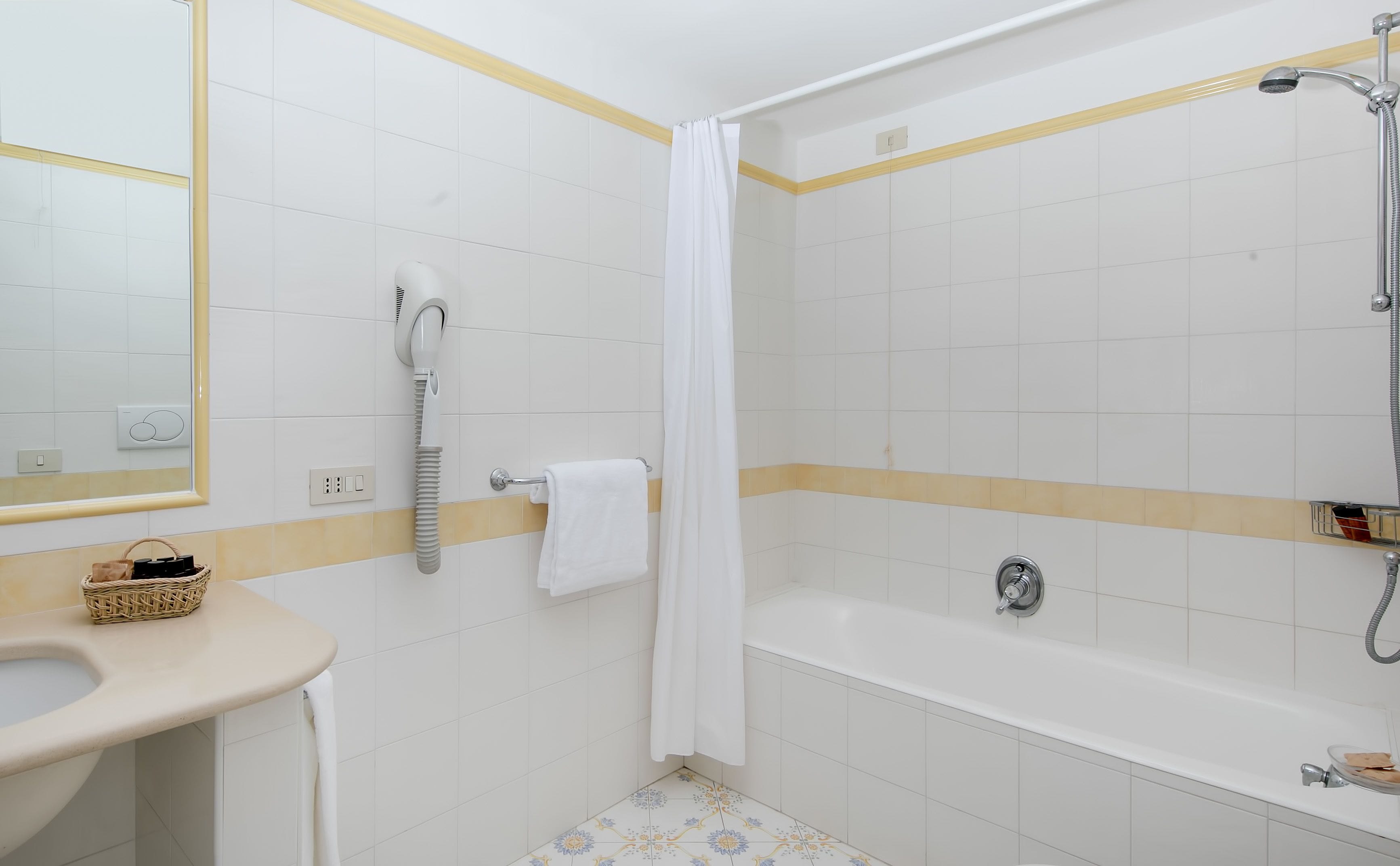 Ein Badezimmer mit einem weißen Waschbecken, einer weißen Toilette, einer Badewanne und einer Dusche.