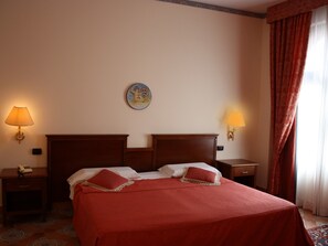 A hotel room with a large bed, two bedside tables, a nightstand, a wall clock, and a window with curtains. - Hotel Baglio Conca D'Oro (Palermo)