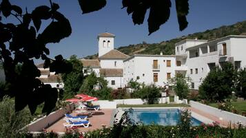 Een seizoensgebonden buitenzwembad en parasols bij het zwembad