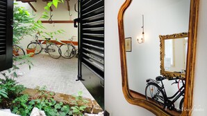 A bicycle parked in a courtyard with a tiled floor and potted plants. - Locanda della Biscia (Ferrara)