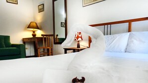 A bed with a swan-shaped pillow and a dog lying on it. - Locanda della Biscia (Ferrara)