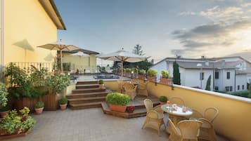 Relax in style with comfortable wicker seating and lush greenery.