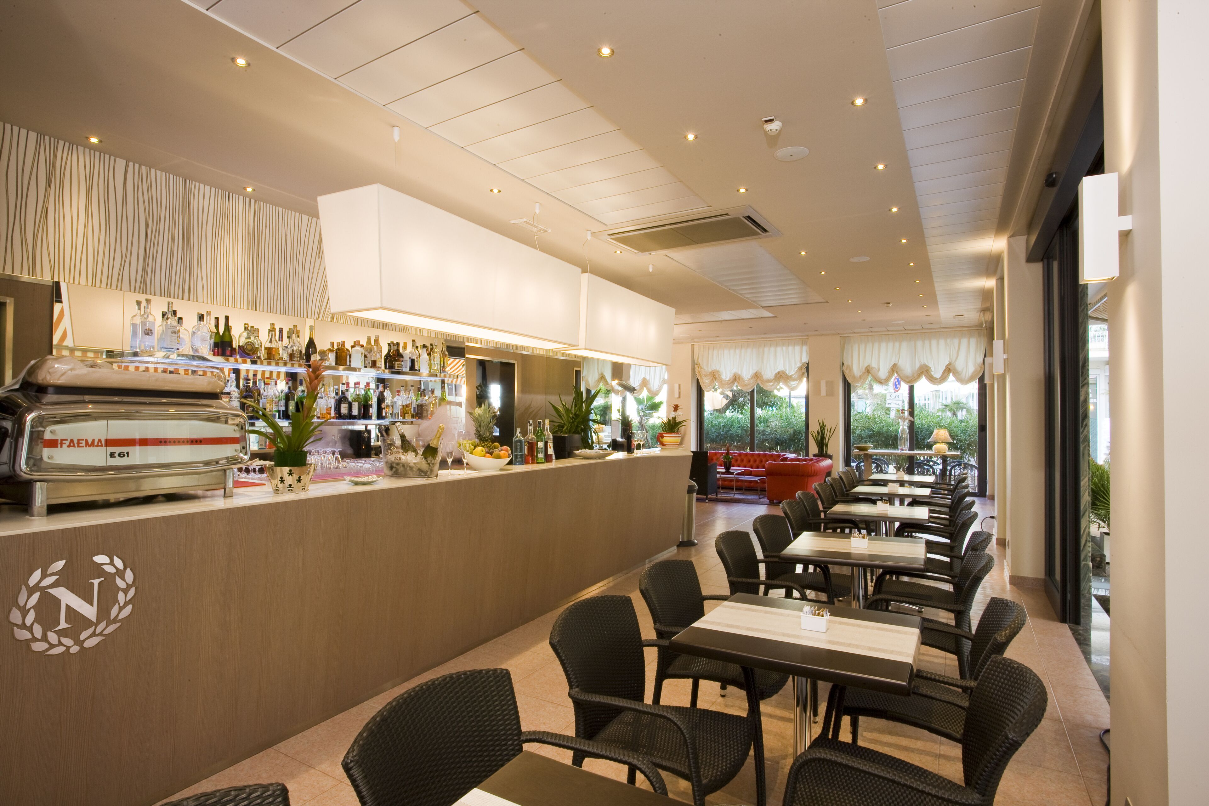 Un restaurant doté d’un bar, de chaises et de tables en osier.