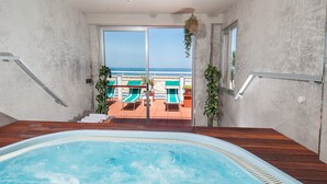 A pool area with a view of the beach and lounge chairs. - Hotel Napoleon (Gabicce Mare)