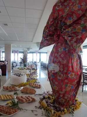 A buffet table with various food items and a large decorative gift. - Hotel Napoleon (Gabicce Mare)