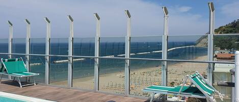 A pool area with clear views of the beach and ocean.