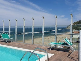 Una piscina al aire libre de temporada, sillones reclinables de piscina